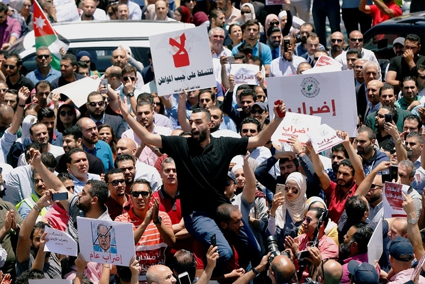 Jordanian people and associations chant slogans during a strike against the new income tax law, in Amman