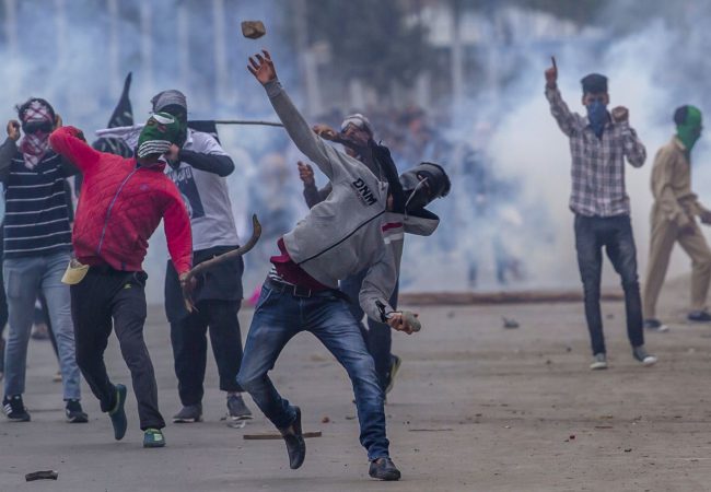 Masked Kashmiri protesters throw rocks at government forces during a protest outside Eidgha, a prayer ground, in Srinagar, Indian controlled Kashmir, Saturday, Sept. 2, 2017. Indian forces used tear gas and pellet guns to disperse hundreds of stone-throwing protesters who took to the streets after Eid al-Adha prayers Saturday, protesting Indian rule. (AP Photo/Dar Yasin)